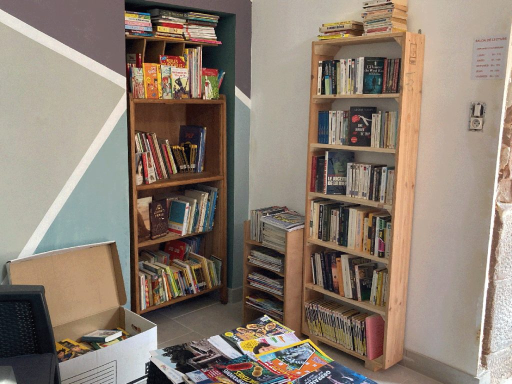 Deux étagères et un petit meuble remplis de livres