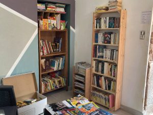Deux étagères et un petit meuble remplis de livres